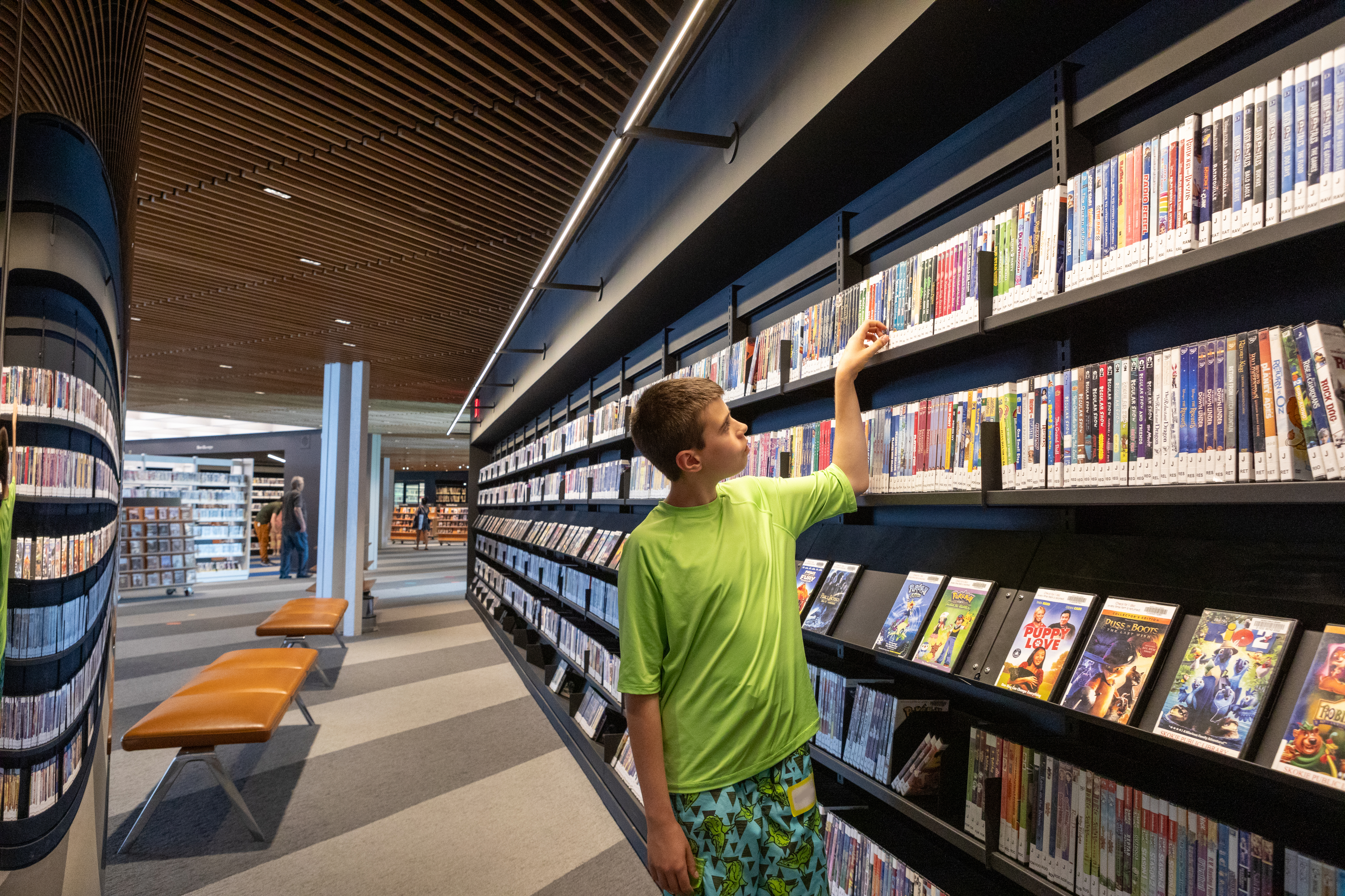 a preteen is browsing DVDs for families. 